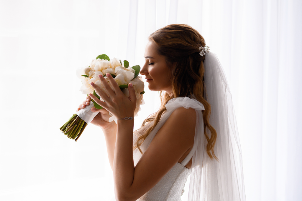 bride-inwedding-dress-holding-sniffing-wedding-bouquet